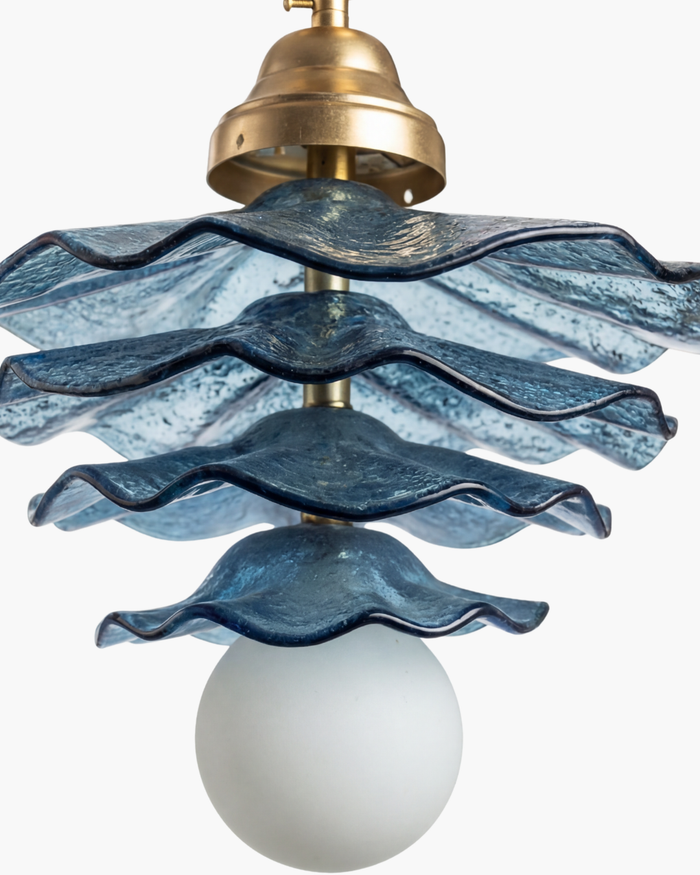 Chandelier with blue wavy glass shades and brass fixture on a white background