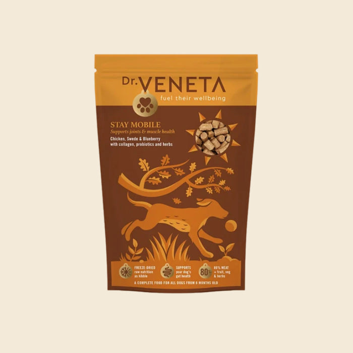 A stand-up pouch of Dr. Veneta Stay Mobile dog food, featuring a brown and golden-yellow design with an illustration of a running dog and a bone, set against a solid cream background.