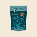A stand-up pouch of Dr. Veneta Stay Well dog supplements, featuring a teal and dark teal design with a dog silhouette, leaf illustrations, and a circular inset showing the brown capsules inside.